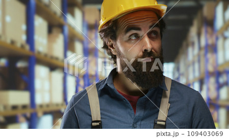 Warehouse engineer verifying stock packages of industrial goods, looking at storage room labels on boxes. Packaging manager working on inventory management, ensuring supply chain production. 109403069