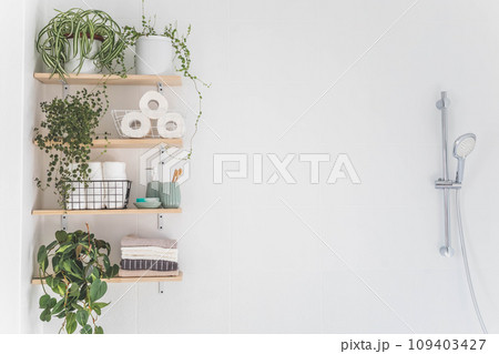 Beautiful white bathroom. Wooden shelves. Rolled towels, stacked towels and baskets. Beautiful white bathroom. Wooden shelves. Rolled towels, stacked towels and baskets. 109403427