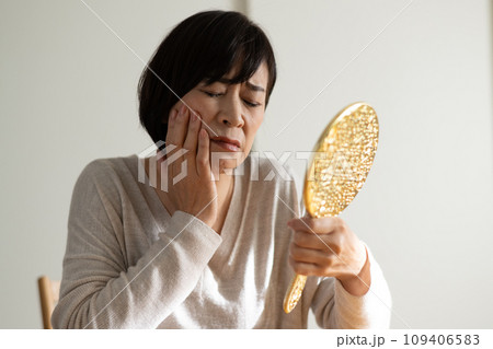 鏡を見る・お肌の調子で悩む50代の女性 鏡を見る・お肌の調子で悩む50代の女性 109406583