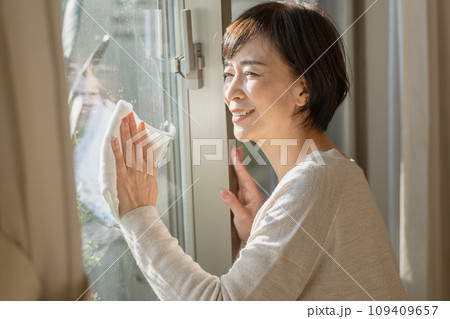 窓掃除をする50代の女性 109409657