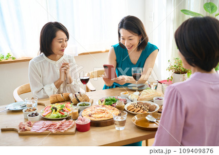 スマートフォンで料理の写真を撮る女性 109409876
