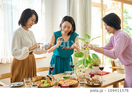 スマートフォンで料理の写真を撮影する女性 109411376