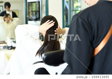 女性客のヘアスタイリングをする男性美容師 女性客のヘアスタイリングをする男性美容師 109411695