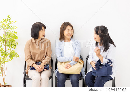 待合室でおしゃべりする女性 109412162