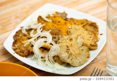Salad of pickled wild mushrooms and sliced onion on plate 109413381