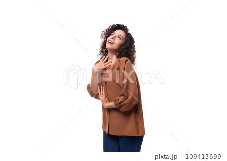 portrait of a young european curly woman with curled hair on a curling iron in a brown blouse portrait of a young european curly woman with curled hair on a curling iron in a brown blouse 109413699
