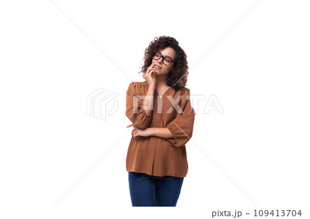 young well-groomed caucasian woman with curly black hair dressed in a brown blouse is brainstorming young well-groomed caucasian woman with curly black hair dressed in a brown blouse is brainstorming 109413704