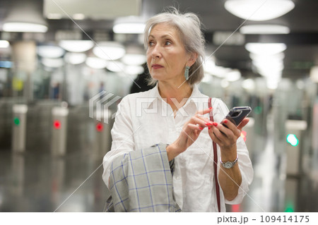 Caucasian woman with smartphone in subway station Caucasian woman with smartphone in subway station 109414175