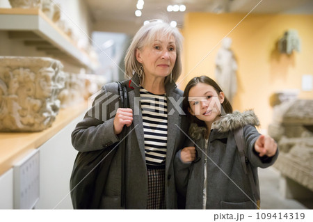 Senior woman and preteen girl viewing ancient sculptures in museum 109414319