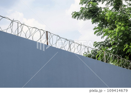 Wall with barbed wire fence 109414679