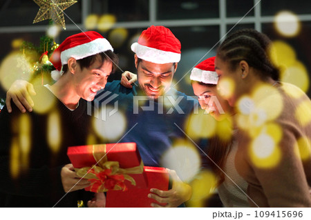 Group of diverse ethnicity people enjoy celebrating a Christmas Eve and New Year party together, friends exchanging a presents together in Christmas Eve and New Year festival party. Group of diverse ethnicity people enjoy celebrating a Christmas Eve and New Year party together, friends exchanging a presents together in Christmas Eve and New Year festival party. 109415696