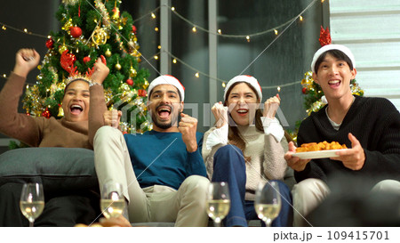 Group of diverse ethnicity young people enjoy celebrating a Christmas and New Year party together with a lot of foods and drinks. Friends celebrate Christmas and New Year festival and drink a wine. 109415701