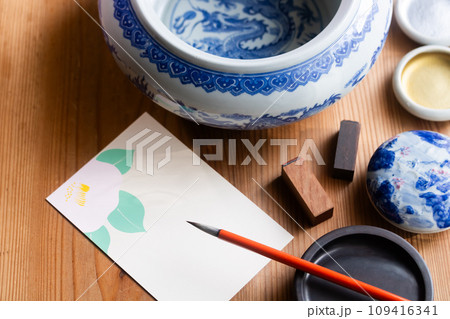 椿の絵葉書に季節の便りを筆でしたためる 109416341