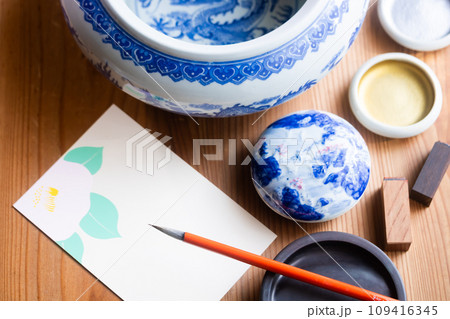 椿の絵葉書に季節の便りを筆でしたためる 109416345