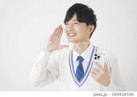 スマートフォンを持って話しかける男子高校生 白背景 スマートフォンを持って話しかける男子高校生 白背景 109416506