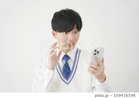 スマートフォンを見て驚く男子高校生 白背景 スマートフォンを見て驚く男子高校生 白背景 109416596