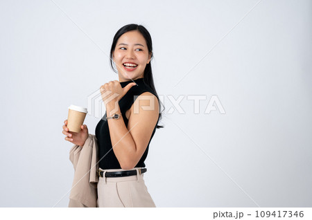 A beautiful Asian businesswoman is pointing her thumb backward at an empty space on white background A beautiful Asian businesswoman is pointing her thumb backward at an empty space on white background 109417346