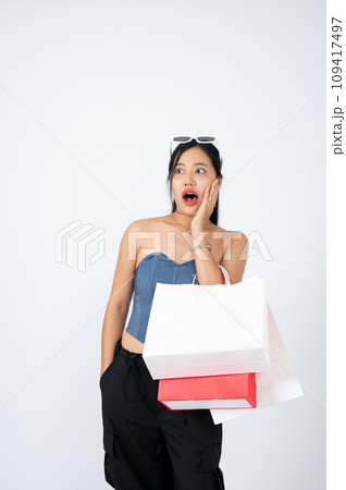 An elegant Asian woman with her shopping bags is stunned and surprised with shopping discount. 109417497