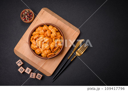 Delicious fresh pasta with pesto sauce, salt, spices and herbs on a ceramic plate 109417796