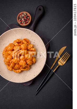 Delicious fresh pasta with pesto sauce, salt, spices and herbs on a ceramic plate 109417815