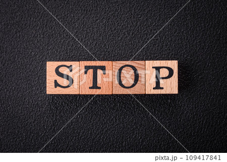 The inscription stop on wooden cubes on a dark concrete background The inscription stop on wooden cubes on a dark concrete background 109417841