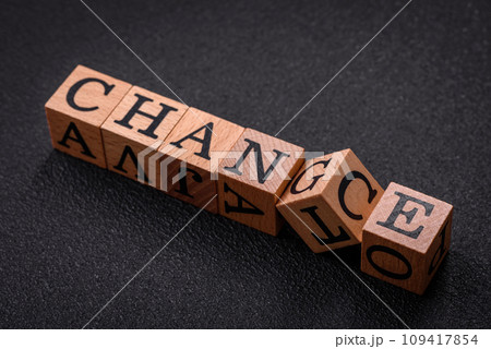 The inscription chance or change with wooden cubes on a dark concrete background 109417854