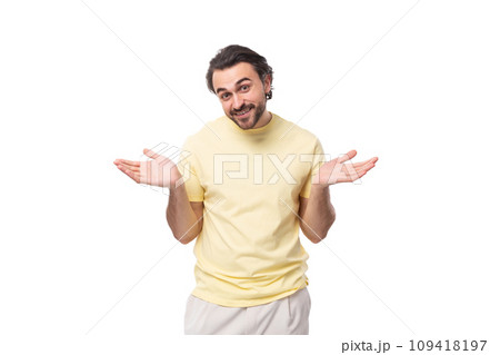 caucasian smart brutal charming guy with a beard dressed in a summer t-shirt spreads his arms 109418197