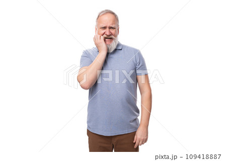 portrait of a gray-haired mature man with a beard and mustache in a t-shirt and trousers on a white 109418887