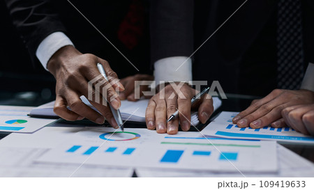 business colleagues look at the graph on the table from above business colleagues look at the graph on the table from above 109419633