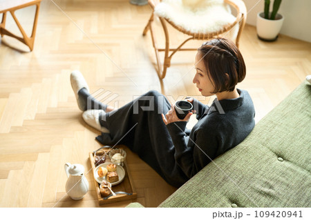 ゆっくりお茶を飲む女性 109420941