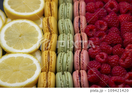 macaroons of different colors with raspberries and lemon 109421420