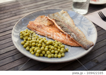 Delicious baked trout fillet with green peas 109422105