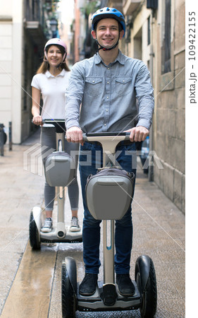 Young couple guy and girl walking on segway in streets of european city 109422155