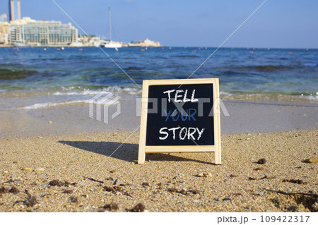 Tell your story symbol. Concept words Tell your story on black chalk blackboard. Beautiful sea background. Business and Tell your story concept. Copy space. 109422317
