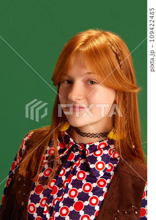 Close-up portrait of red haired cheerful, smiling young cowgirl, teenager looking at camera against green studio background. Close-up portrait of red haired cheerful, smiling young cowgirl, teenager looking at camera against green studio background. 109422485