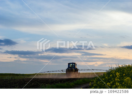 Tractor spraying pesticides on vegetable field with sprayer at spring Tractor spraying pesticides on vegetable field with sprayer at spring 109422586