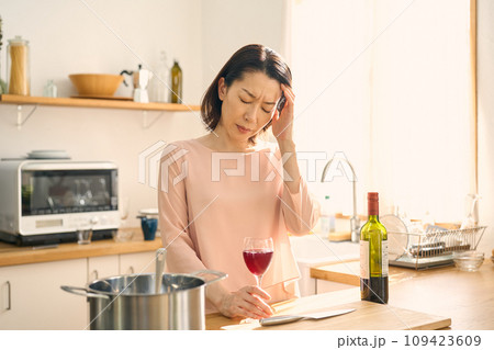 キッチンでワインを飲む女性 109423609