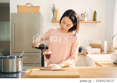 キッチンでワインを飲む女性 109423615