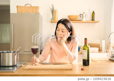 キッチンでワインを飲む女性 109423616