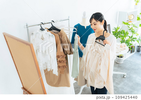 アパレルショップで洋服を選ぶ女性 アパレルショップで洋服を選ぶ女性 109425440