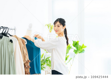アパレルショップで商品を陳列する女性店員 アパレルショップで商品を陳列する女性店員 109425444