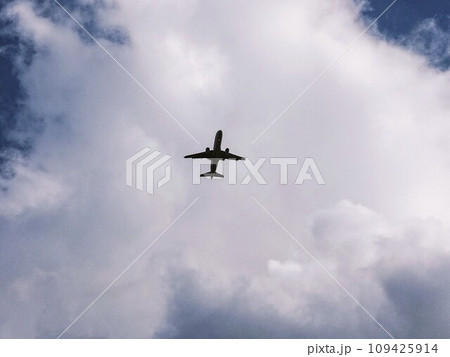 白い雲に飛行機のシルエット　231205 109425914