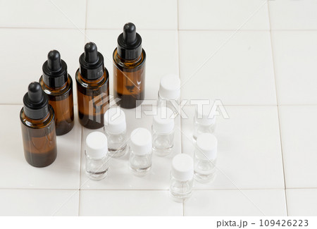白いタイルに並べた茶色い遮光瓶と小分け用ボトル 白いタイルに並べた茶色い遮光瓶と小分け用ボトル 109426223