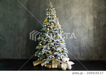 Christmas tree for new year with gifts in dark grey room interior Christmas tree for new year with gifts in dark grey room interior 109428517