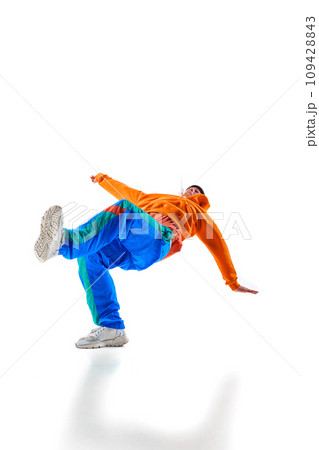 Stylishly dressed man, guy, professional dancer performing freestyle, breakdance freezes, flexing against white background. Stylishly dressed man, guy, professional dancer performing freestyle, breakdance freezes, flexing against white background. 109428843