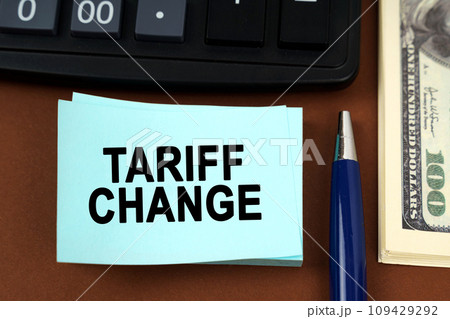 On a brown surface lies a calculator, dollars, pens and stickers with the inscription - Tariff Change On a brown surface lies a calculator, dollars, pens and stickers with the inscription - Tariff Change 109429292