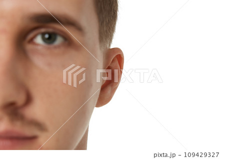 Close up of male ear on white studio background Close up of male ear on white studio background 109429327