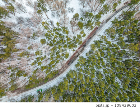 Flight over the winter mountains with road serpentine and pine forest. Top down view. Landscape photography Flight over the winter mountains with road serpentine and pine forest. Top down view. Landscape photography 109429602