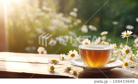 cup of tea with chamomile flowers against a wooden table, 109433649