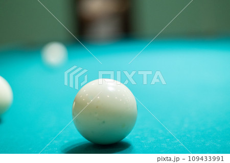 A green billiard table with balls lying on it without people. A beautiful billiard table stands in an empty room with white balls lying on it. Empty billiard table concept with balls. A green billiard table with balls lying on it without people. A beautiful billiard table stands in an empty room with white balls lying on it. Empty billiard table concept with balls. 109433991